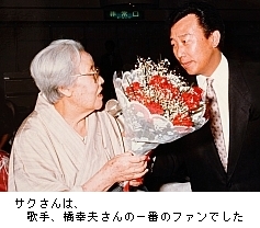写真:幸夫さんに花束を渡す母のサクさん。サクさんは、歌手、橋さんの一番のファンでした