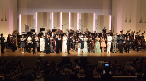 写真：贈呈式の全景。舞台上で歌手代表の五木ひろしさんから贈呈先代表者へ目録が手渡される