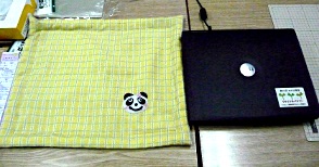 写真：パソコンとパンダのアップリケが施された持ち持ち運び用の袋。
